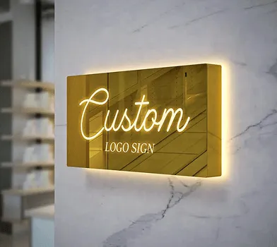 Gold 'Custom Logo Sign' plaque mounted on a marble wall.