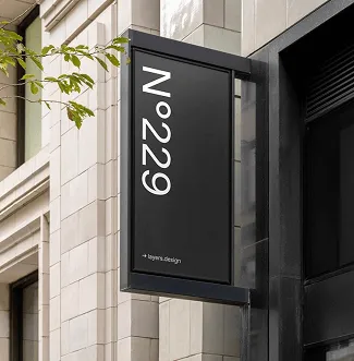 Black blade storefront sign with vertical 'No. 229' lettering on a city facade.