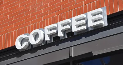 Channel-letter sign spelling 'COFFEE' on a brick facade.